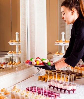 How to reduce food and beverage costs at your European wedding A caterer providing desserts for a wedding.